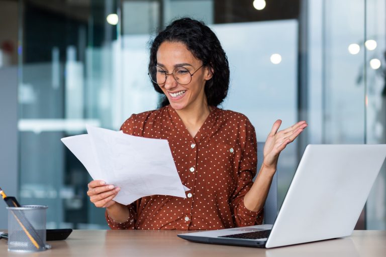 A Latin American woman writer, journalist in the office, holds papers, writes an article, a book